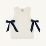 The Beaufort Bonnet Company’s Shae Sweater Vest in Palmetto Pearl with Nantucket Navy features ribbed edges and two large navy blue bows on each side, crafted from 100% cotton. Laid flat against a plain, light background, this sleeveless vest is the perfect addition to any girl’s autumn wardrobe.