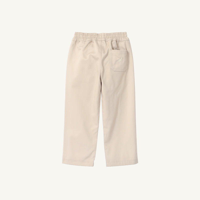Back view of light tan cotton twill Sheffield Pants - Keeneland Khaki with Keeneland Khaki Stork, featuring an elastic waist and a single back pocket with a small bird embroidery.