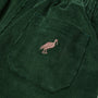 Close-up of The Beaufort Bonnet Company’s Sheffield Pants in Grier Green corduroy, featuring a stitched Gray Bay Brown stork on the pocket—perfect for fall activities.