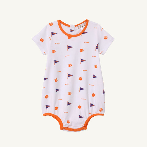 The Beaufort Bonnet Company Clemson Short Sleeve Patton Play Bubble - Tiger Triumph with Clemson Orange is a white baby romper with orange trim, short sleeves, and convenient bottom snaps. It features an all-over print of small orange Tiger paws and purple pennants with “CLEMSON” text, perfect for celebrating Tiger Triumph spirit.