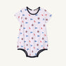 Ole Miss Short Sleeve Patton Play Bubble - Gawsh Almighty with Nantucket Navy by The Beaufort Bonnet Company, crafted from soft Pima Cotton and adorned with small blue flags and circular red, white, and blue emblems. Finished with dark blue trim along the neck, sleeves, and leg openings—perfect for little Ole Miss fans.