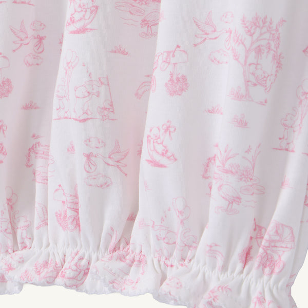 The Sir Proper’s Sweet Arrival (Hamptons Hot Pink) Bundle - Adorable Everyday Set & Bradley Bear by The Beaufort Bonnet Company features soft white Pima cotton adorned with pink illustrations of animals, trees, and children at play, and is gathered with elastic at the bottom hem—making it a perfect baby shower gift.