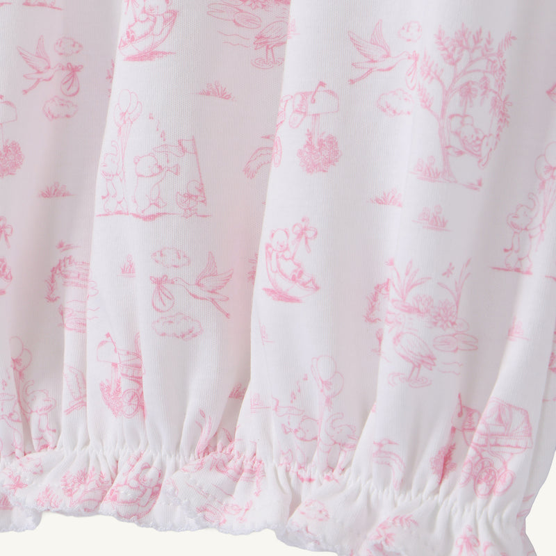The Sir Proper’s Sweet Arrival (Hamptons Hot Pink) Bundle - Adorable Everyday Set & Bradley Bear by The Beaufort Bonnet Company features soft white Pima cotton adorned with pink illustrations of animals, trees, and children at play, and is gathered with elastic at the bottom hem—making it a perfect baby shower gift.