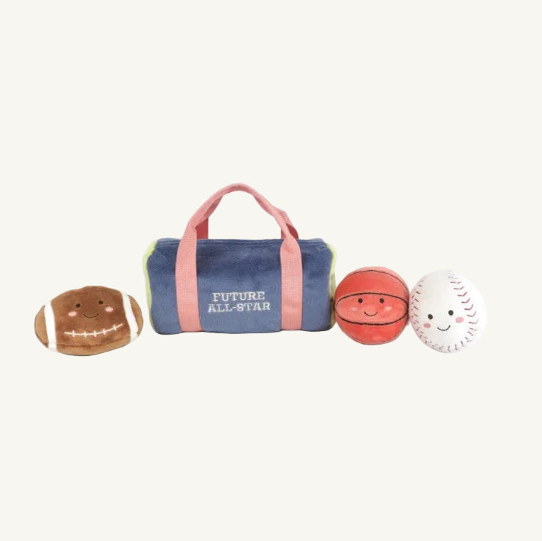 A plush duffel bag from The Beaufort Bonnet Company, called the Sports Play Bag - Mon Ami, features three smiling plush sports balls—a football, basketball, and baseball—arranged in front of a plain background. This adorable plush sports toy makes a perfect baby gift and encourages sensory play.