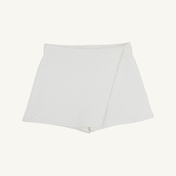 Stella Skort - Quilted Palmetto Pearl by The Beaufort Bonnet Company: A white quilted skort featuring a wrap-style front and a subtle diamond pattern, perfect as girls’ skirt shorts, shown against a plain white background.