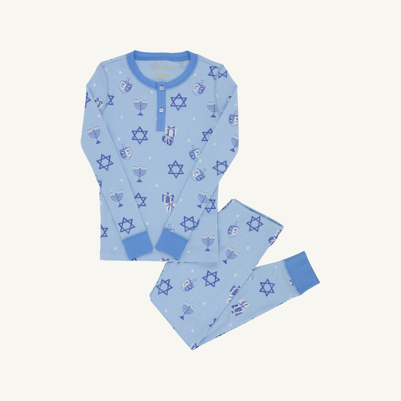 Introducing the Sutton’s Sweet Dream Set - Eight Nights to Remember with Barbados Blue by The Beaufort Bonnet Company: a children’s pajama set in light blue, crafted from soft Pima cotton with long sleeves and pants, blue cuffs, and festive Hanukkah-themed prints—Stars of David, menorahs, and dreidels—for a cozy holiday celebration.