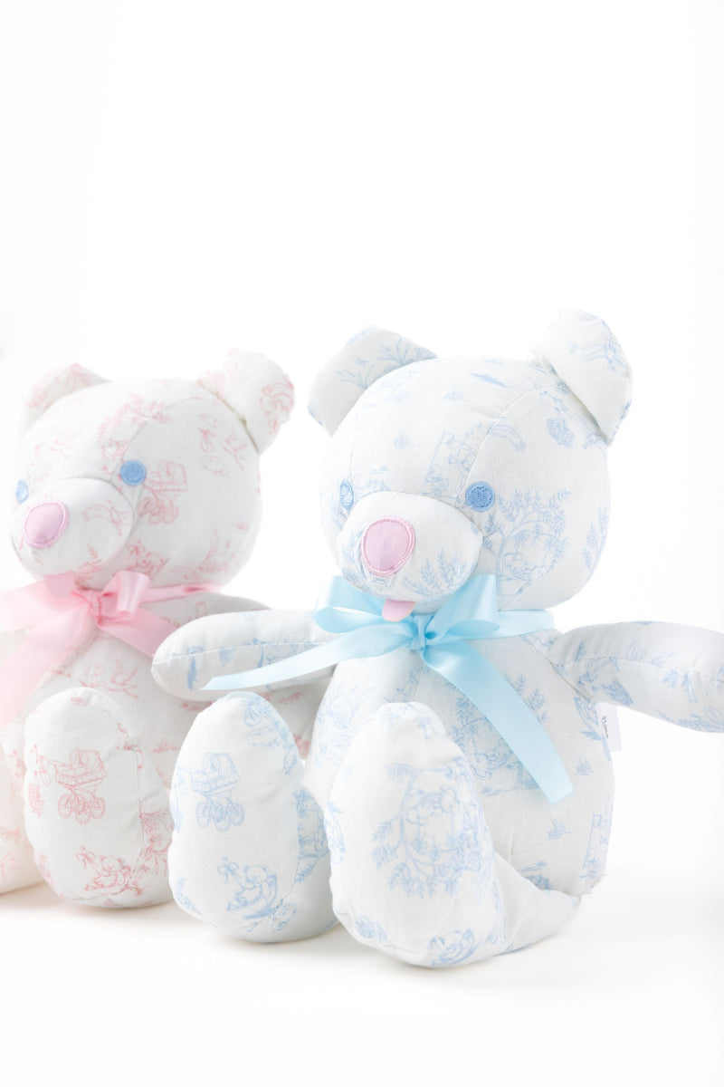 Two plush stuffed bears from The Beaufort Bonnet Company sit side by side against a white backdrop. One is the Bradley Bear, featuring charming blue accents and a blue ribbon, while the other boasts lovely pink details and a matching ribbon—making Sir Proper’s Sweet Arrival (Beale Street Blue) Bundle an ideal baby shower gift.