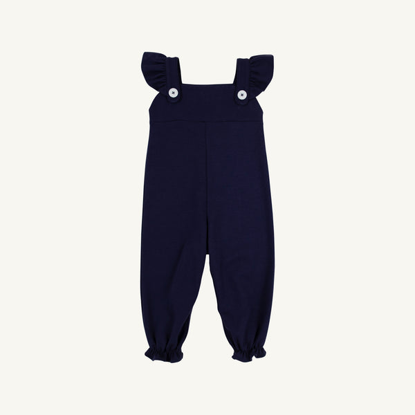 Violet’s Vintage Overalls in Nantucket Navy with Worth Avenue White by The Beaufort Bonnet Company feature ruffled shoulder straps, two white buttons on the front, and elasticized ankle cuffs. Crafted from soft Pima Cotton Knit, they are displayed against a plain white background.
