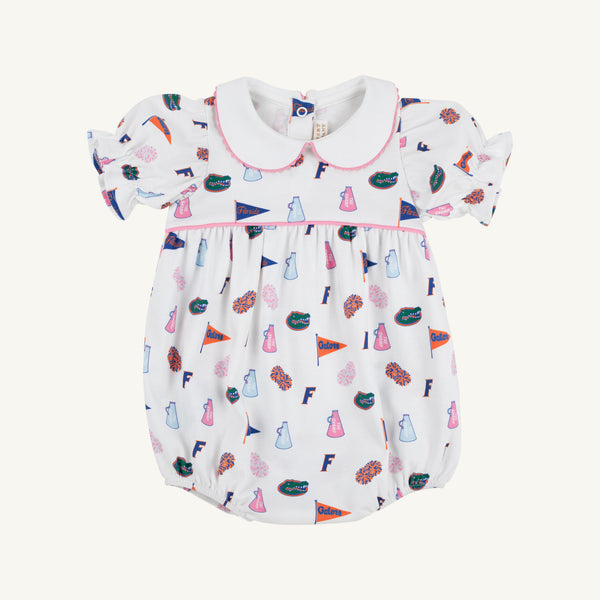 The Beaufort Bonnet Company’s Florida Britt Bubble - Florida Forever with Hamptons Hot Pink is a white baby romper crafted from soft Pima Cotton Knit in their signature bubble style, featuring puff sleeves and a Peter Pan collar. The cheerful Florida Forever print showcases colorful footballs, pom-poms, cheer skirts, megaphones, and flags—perfect for celebrating the University of Florida.