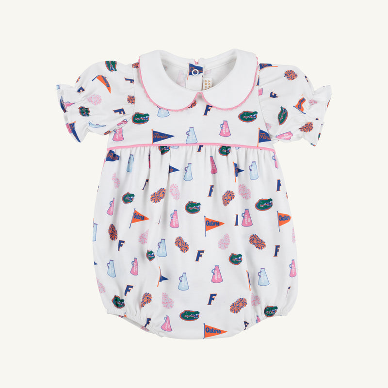 The Beaufort Bonnet Company’s Florida Britt Bubble - Florida Forever with Hamptons Hot Pink is a white baby romper crafted from soft Pima Cotton Knit in their signature bubble style, featuring puff sleeves and a Peter Pan collar. The cheerful Florida Forever print showcases colorful footballs, pom-poms, cheer skirts, megaphones, and flags—perfect for celebrating the University of Florida.