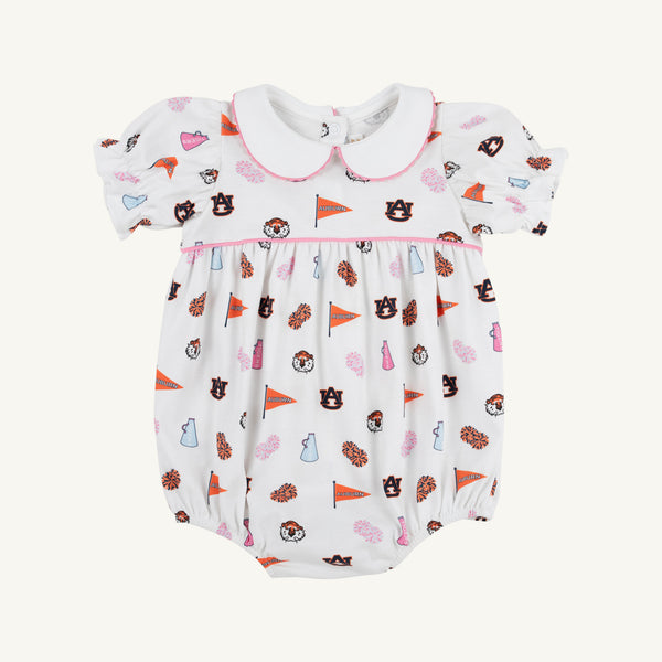 The Auburn Britt Bubble - Tiger Thrill with Hamptons Hot Pink by The Beaufort Bonnet Company is a white baby romper featuring puff sleeves, a Peter Pan collar, and a colorful Auburn University-themed Tiger Thrill print with pennants, pom-poms, hearts, and tiger mascots. Crafted from soft Pima Cotton Knit, it includes convenient snap closures at the bottom.