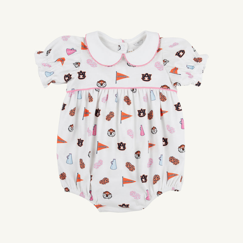 The Auburn Britt Bubble - Tiger Thrill with Hamptons Hot Pink by The Beaufort Bonnet Company is a white baby romper featuring puff sleeves, a Peter Pan collar, and a colorful Auburn University-themed Tiger Thrill print with pennants, pom-poms, hearts, and tiger mascots. Crafted from soft Pima Cotton Knit, it includes convenient snap closures at the bottom.