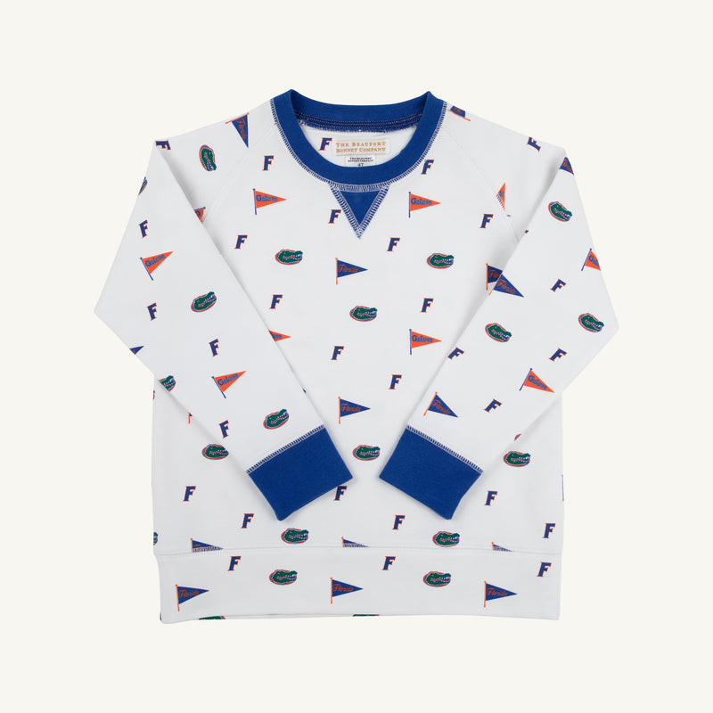 The Beaufort Bonnet Company’s Florida Cassidy Comfy Crewneck - Florida Forever with Florida Blue is a white sweatshirt featuring blue cuffs, adorned with blue “F”s, orange and blue pennants, and alligator logos in a sports-themed university pattern. The shirt is neatly laid flat on a white background.