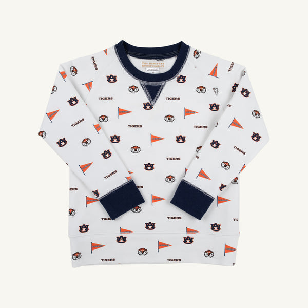 Dress your child in Auburn pride with the Auburn Cassidy Comfy Crewneck - Tiger Thrill with Auburn Blue by The Beaufort Bonnet Company. This cozy white sweatshirt features a navy blue collar and cuffs, and is playfully decorated with scattered Auburn University logos, tiger mascots, orange pennants, and the word “TIGERS” in an all-over pattern—perfect for showing off that true Auburn Blue spirit.