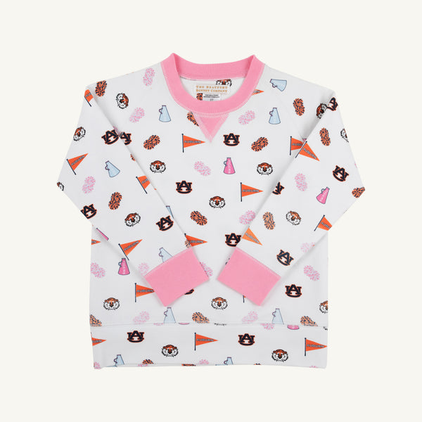 The Auburn Cassidy Comfy Crewneck - Tiger Thrill with Hamptons Hot Pink by The Beaufort Bonnet Company is a children’s long-sleeve white sweatshirt featuring pink cuffs, collar, and hem. The Tiger Thrill print showcases Auburn University logos, orange pennants, megaphones, pom-poms, and tiger mascots for spirited school style.