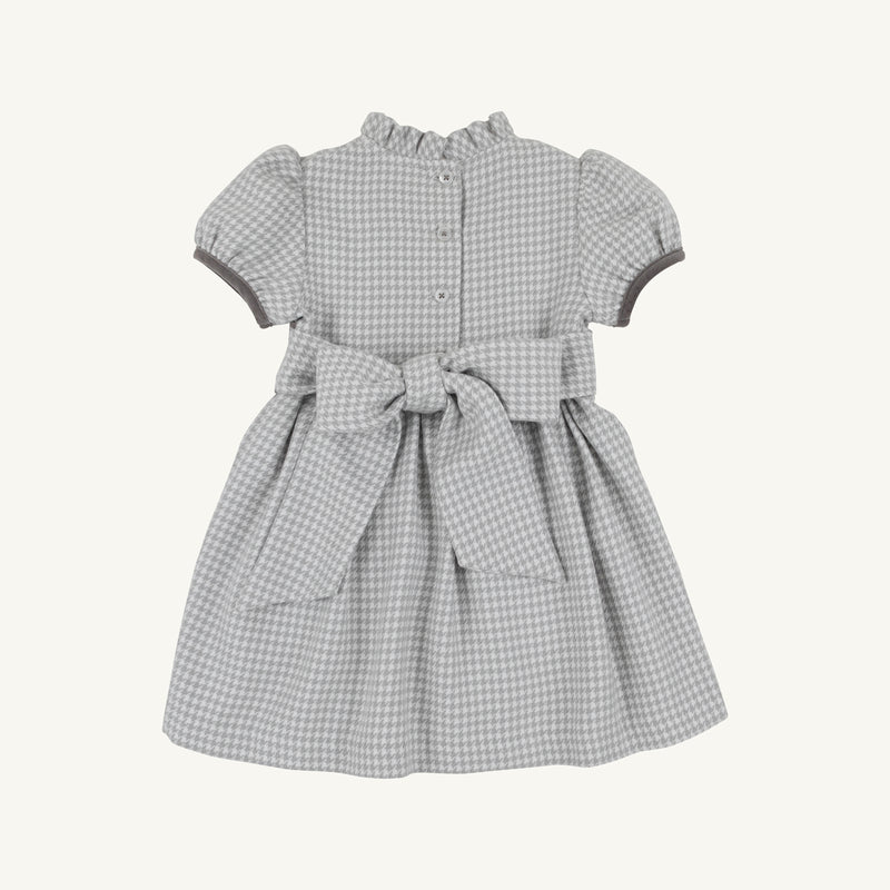 The Beaufort Bonnet Company Cindy Lou Sash Dress in Grantley Gray Houndstooth features short puff sleeves, a ruffled collar, buttons down the back, and a large sash tied at the waist.