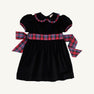 The Cindy Lou Sash Dress - Newport Night Velveteen with Bucktown Tartan by The Beaufort Bonnet Company is a delightful holiday dress for girls, crafted from soft velveteen and adorned with puffed short sleeves, a scalloped collar, and a large red, blue, and green Bucktown Tartan sash tied in a bow at the back—perfect for festive celebrations.