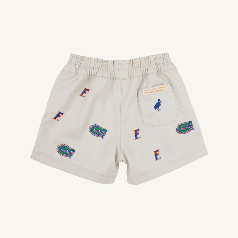 The Beaufort Bonnet Company’s Florida Critter Sheffield Shorts in Saratoga Stone feature a light-colored design with an elastic waistband, decorated with repeating University of Florida Gators logos and blue “F” letters. A small back pocket displays an emu patch and text, making these the perfect kids’ gameday shorts for flaunting your Florida spirit.
