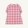Back view of a Lindy’s Lunch Dress - Broadway Play Plaid with Worth Avenue White, a long-sleeved plaid holiday dress in shades of pink, red, and white, featuring a white rounded collar and a vertical row of buttons down the back.