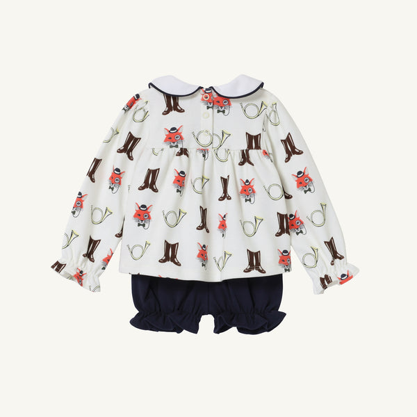 The Long Sleeve Banks Bow Bloomer Set - Happy Hunting with Palmetto Pearl & Nantucket Navy by The Beaufort Bonnet Company features a white long-sleeve baby romper adorned with playful foxes, boots, and horns. It is accented by a navy collar trim and paired with solid navy bubble shorts, making it an ideal baby girl autumn or fall outfit. The garment is displayed on a plain white background, showing the back view.
