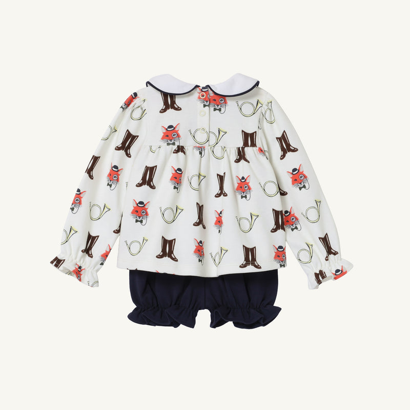 The Long Sleeve Banks Bow Bloomer Set - Happy Hunting with Palmetto Pearl & Nantucket Navy by The Beaufort Bonnet Company features a white long-sleeve baby romper adorned with playful foxes, boots, and horns. It is accented by a navy collar trim and paired with solid navy bubble shorts, making it an ideal baby girl autumn or fall outfit. The garment is displayed on a plain white background, showing the back view.