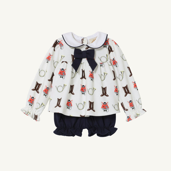 The Beaufort Bonnet Company’s Long Sleeve Banks Bow Bloomer Set – Happy Hunting with Palmetto Pearl & Nantucket Navy features a white long-sleeve top with a ruffled collar, playful horse and boot prints, a navy bow at the neckline, and matching navy ruffle bloomers. This adorable set is perfect as baby girl autumn clothing and makes a charming fall outfit.