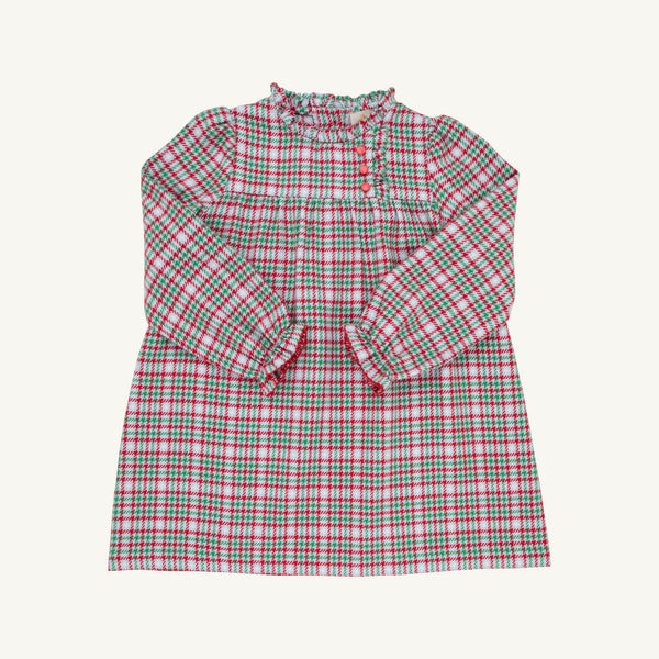 The Beaufort Bonnet Company Long Sleeve Mary Baker Day Dress in Wicker Park Plaid with Richmond Red is a charming toddler girls’ dress featuring a festive red, green, and white plaid pattern. This long-sleeved dress showcases a ruffled collar, ruffled cuffs, and a button-front closure on the bodice. Displayed against a plain off-white background, it’s perfect for your little one as a Christmas or holiday dress.