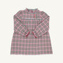The Beaufort Bonnet Company Long Sleeve Mary Baker Day Dress in Wicker Park Plaid with Richmond Red is a charming toddler girls’ dress featuring a festive red, green, and white plaid pattern. This long-sleeved dress showcases a ruffled collar, ruffled cuffs, and a button-front closure on the bodice. Displayed against a plain off-white background, it’s perfect for your little one as a Christmas or holiday dress.