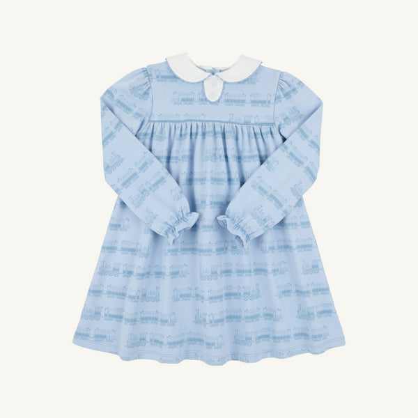 The Beaufort Bonnet Company’s Long Sleeve Mary Dal Dress in Blue Choo Choos with Worth Avenue White features a light blue Pima Cotton Knit design, a charming Peter Pan collar, and a subtle train pattern. This toddler dress is detailed with gathered waist and sleeve accents for added sweetness.