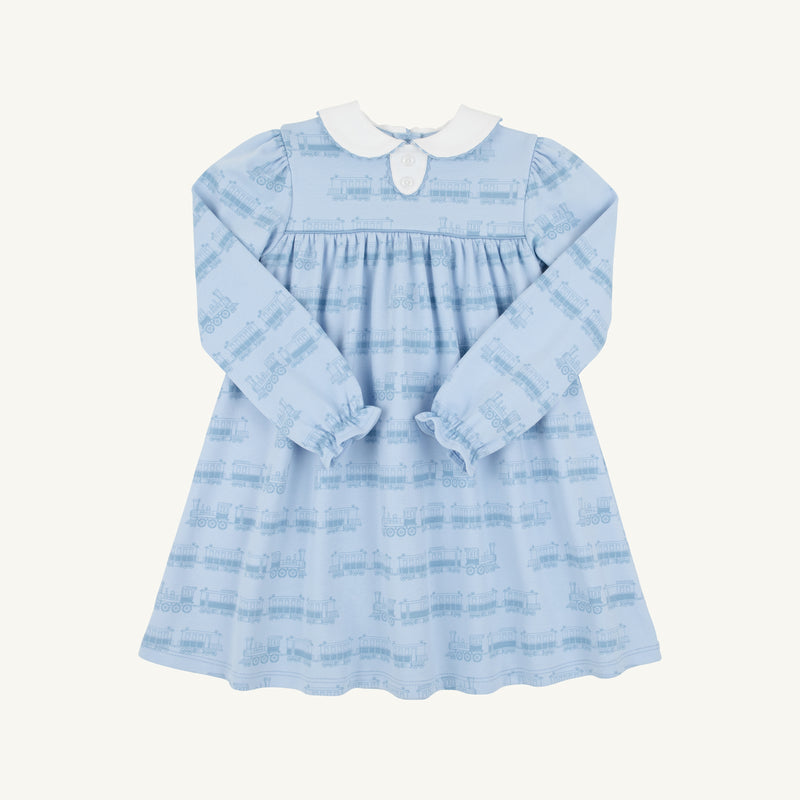 The Beaufort Bonnet Company’s Long Sleeve Mary Dal Dress in Blue Choo Choos with Worth Avenue White features a light blue Pima Cotton Knit design, a charming Peter Pan collar, and a subtle train pattern. This toddler dress is detailed with gathered waist and sleeve accents for added sweetness.