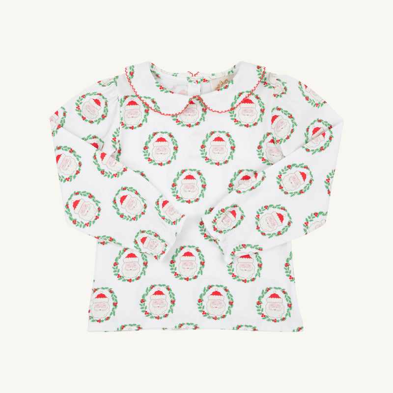 Long Sleeve Maude’s Peter Pan Collar Shirt - North Pole Portrait with Richmond Red by The Beaufort Bonnet Company: a children’s long-sleeve white shirt featuring a red-trimmed Peter Pan collar and a festive red and green Santa Claus wreath pattern, made from soft Pima cotton. The holiday outfit is laid flat on a plain background.