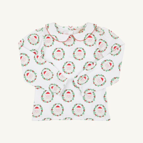 Long Sleeve Maude’s Peter Pan Collar Shirt - North Pole Portrait with Richmond Red by The Beaufort Bonnet Company: a children’s long-sleeve white shirt featuring a red-trimmed Peter Pan collar and a festive red and green Santa Claus wreath pattern, made from soft Pima cotton. The holiday outfit is laid flat on a plain background.