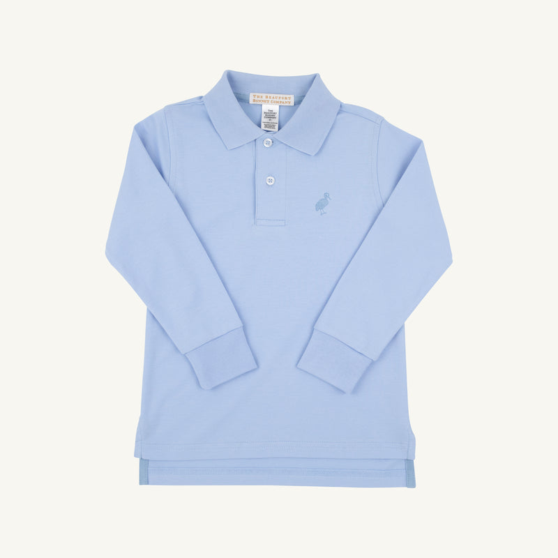 Long Sleeve Prim & Proper Polo by The Beaufort Bonnet Company in Beale Street Blue with a Barrington Blue stork embroidered on the chest, featuring a collar and two buttons, laid flat on a white background.
