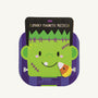 A cartoon Frankenstein face appears on a purple background labeled “Monster Magnetic Puzzle Book - Mud Pie” by The Beaufort Bonnet Company, featuring a candy corn magnet on its cheek. This magnetic puzzle is a fun travel toy and creative activity. Warning: Choking hazard—small parts. Not for children under 3 years.
