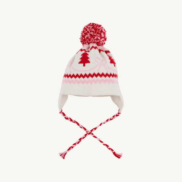 A Parrish Pom Pom Hat in Palmetto Pearl by The Beaufort Bonnet Company, featuring ear flaps, braided tassels, a pom-pom on top, and a festive pattern of bows and Christmas trees.