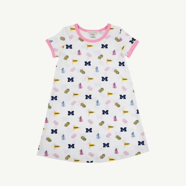 The Beaufort Bonnet Company’s Michigan Polly Play Dress - Bold in Blue with Hamptons Hot Pink features a white short-sleeve design trimmed in pink and decorated with University of Michigan M logos, yellow pennants, pom-poms, and megaphones. Made from 100% Pima Cotton for ultimate comfort, it’s perfect for showing your Bold in Blue spirit!.