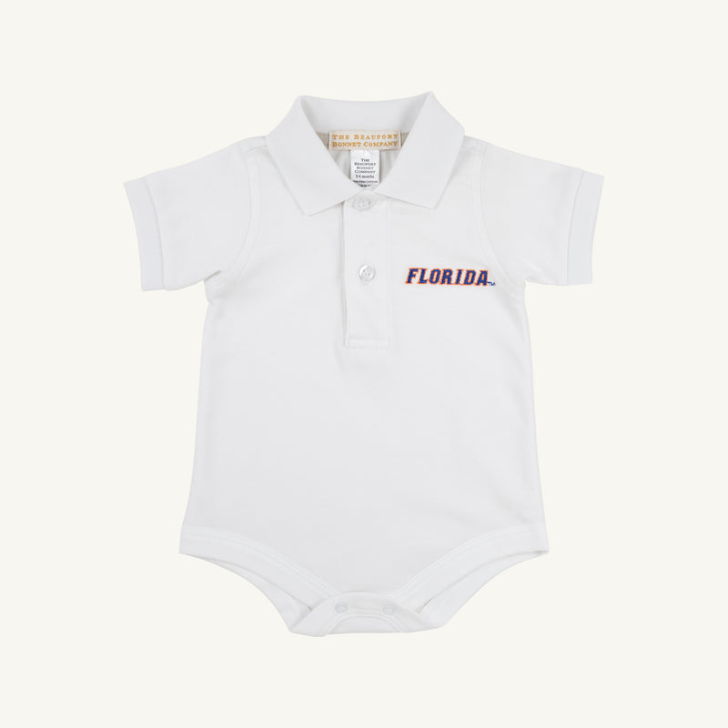 The Florida Prim & Proper Polo – Worth Avenue White by The Beaufort Bonnet Company is a white baby onesie with a collar, short sleeves, and an embroidered blue and orange Florida logo on the left chest. Made from soft Pima Cotton Knit, this onesie features three buttons at the neck and convenient snaps at the bottom.