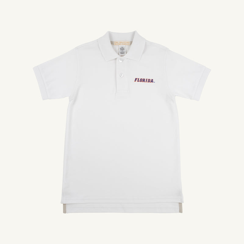 The Beaufort Bonnet Company’s Florida Prim & Proper Polo – Worth Avenue White is a short-sleeve, collared shirt with three buttons, made from soft Pima Cotton Knit. It features an embroidered red Florida logo on the left chest and is displayed against a plain off-white background.
