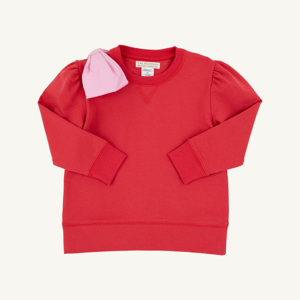 Introducing the Puff Sleeve Cassidy Comfy Crewneck in Richmond Red with a Pier Party Pink Bow by The Beaufort Bonnet Company—a girls’ red crewneck sweatshirt featuring long puff sleeves, puffed shoulders, and a pink bow attached to the left shoulder, shown against a plain white background.