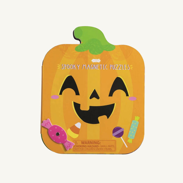 A Pumpkin Magnetic Puzzle Book by The Beaufort Bonnet Company, shaped like an orange pumpkin tin and decorated with a smiling face and colorful candy illustrations, sits on a plain background. This fun, screen-free activity from Mud Pie includes a warning for small parts and offers entertainment as a magnetic puzzle set.