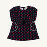 The Beaufort Bonnet Company Sadie Sweatshirt Dress - Prescott Farm Flowers with Worth Avenue White is a navy blue long-sleeved dress featuring a repeating floral pattern, two front pockets with white trim, and white button accents.