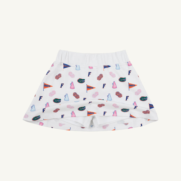 Crafted by The Beaufort Bonnet Company, the Florida Searcy Skort - Florida Forever with Worth Avenue White features a soft Pima Cotton Knit fabric with a comfortable elastic waistband. This white skort is adorned with the playful Florida Forever print, showcasing colorful footballs, pom-poms, pennants, letter Fs, and megaphones on a crisp background.