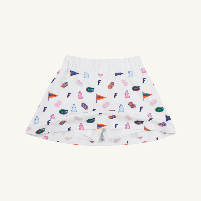 Crafted by The Beaufort Bonnet Company, the Florida Searcy Skort - Florida Forever with Worth Avenue White features a soft Pima Cotton Knit fabric with a comfortable elastic waistband. This white skort is adorned with the playful Florida Forever print, showcasing colorful footballs, pom-poms, pennants, letter Fs, and megaphones on a crisp background.