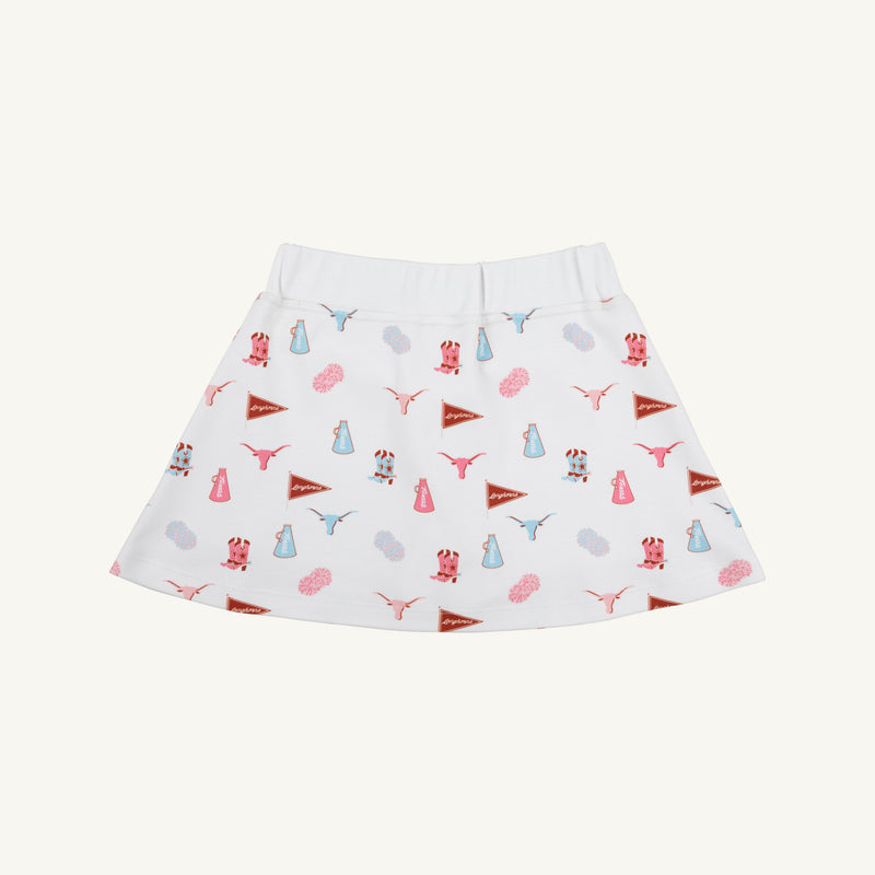 The Texas Searcy Skort - Gone to Texas with Worth Avenue White by The Beaufort Bonnet Company features a playful all-over Gone to Texas print showcasing red and blue pennants, cheerleader megaphones, pom-poms, and cow heads. This vibrant and colorful design pops against the crisp white background.