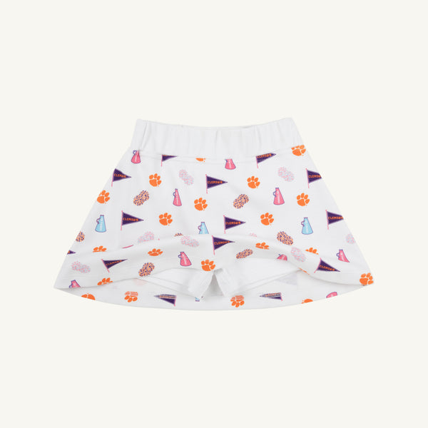 Clemson Searcy Skort - Tiger Triumph with Worth Avenue White by The Beaufort Bonnet Company, featuring orange paw prints, purple pennant flags, and blue and pink megaphone and pom-pom illustrations on a white background, displayed on a plain light surface.
