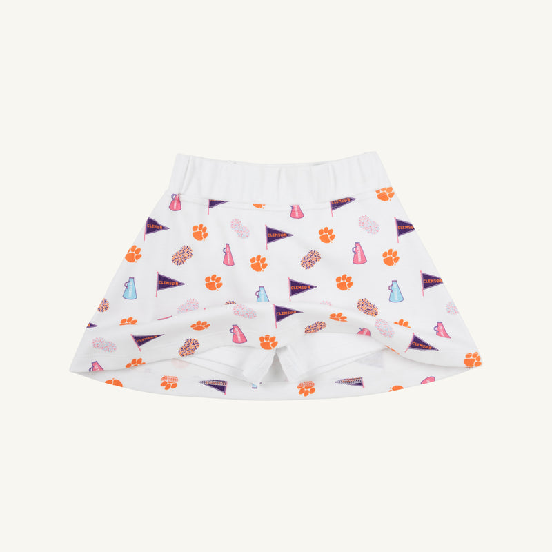 Clemson Searcy Skort - Tiger Triumph with Worth Avenue White by The Beaufort Bonnet Company, featuring orange paw prints, purple pennant flags, and blue and pink megaphone and pom-pom illustrations on a white background, displayed on a plain light surface.