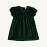 The Beaufort Bonnet Company’s Short Sleeve Patsy’s Party Dress in Grier Green Velveteen with Nantucket Navy features puffed short sleeves, a square yoke, navy blue trim, and gentle pleats for a simple, classic holiday look. The toddler dress is laid flat on a white background.