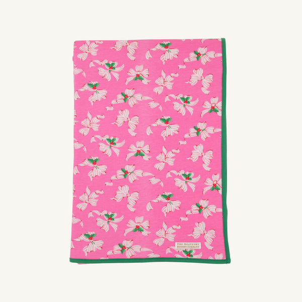 The Silent Night Throw - Bows of Holly with Kiawah Kelly Green by The Beaufort Bonnet Company features a charming pattern of white and pink flowers with green leaves, bordered by a solid green edge, and is crafted from soft Pima Cotton Knit for added comfort.