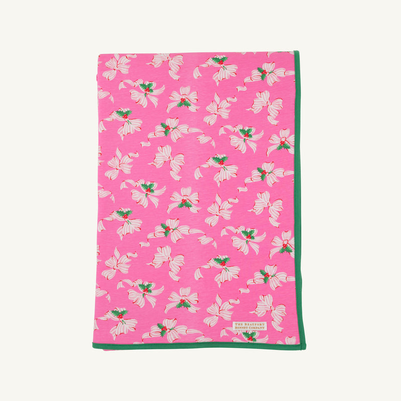 The Silent Night Throw - Bows of Holly with Kiawah Kelly Green by The Beaufort Bonnet Company features a charming pattern of white and pink flowers with green leaves, bordered by a solid green edge, and is crafted from soft Pima Cotton Knit for added comfort.