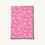 The Silent Night Throw - Bows of Holly with Kiawah Kelly Green by The Beaufort Bonnet Company features a charming pattern of white and pink flowers with green leaves, bordered by a solid green edge, and is crafted from soft Pima Cotton Knit for added comfort.